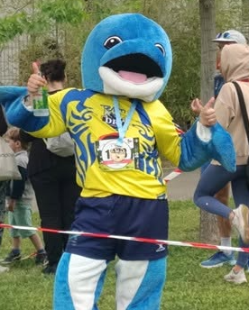 Dauphi, la mascotte du DRL, en maillot jaune et bleu, pouce levé